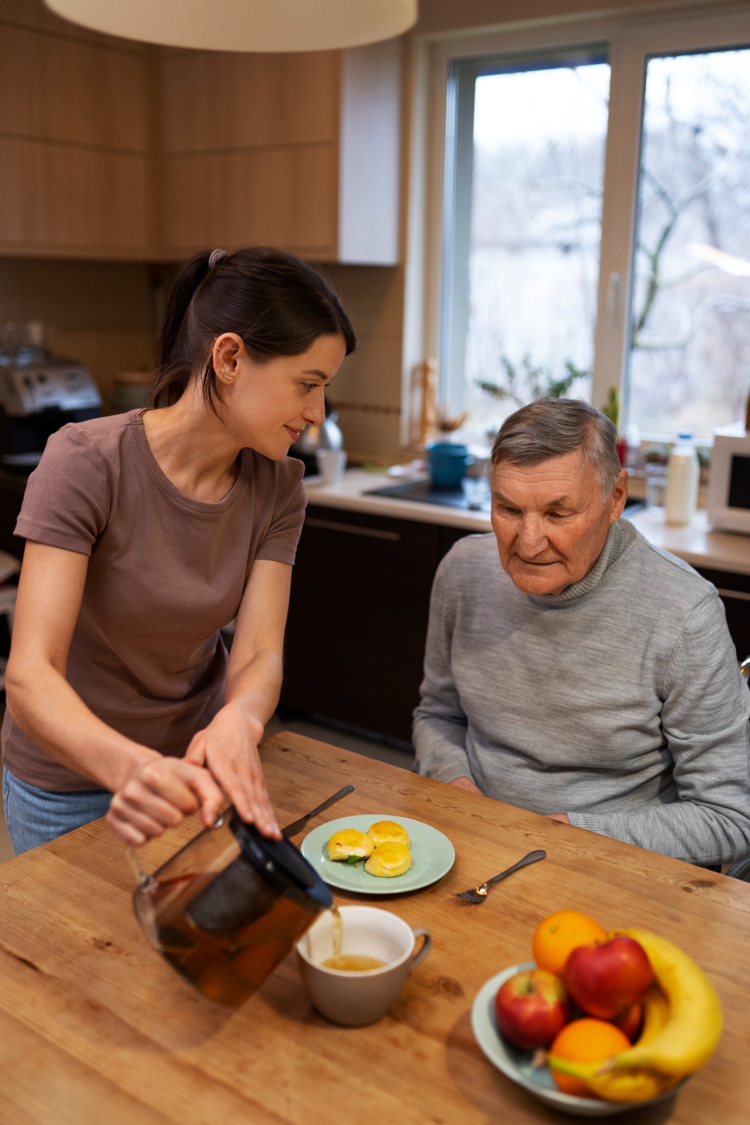 A woman serving food for a pensioner with a loving smile and looking his face